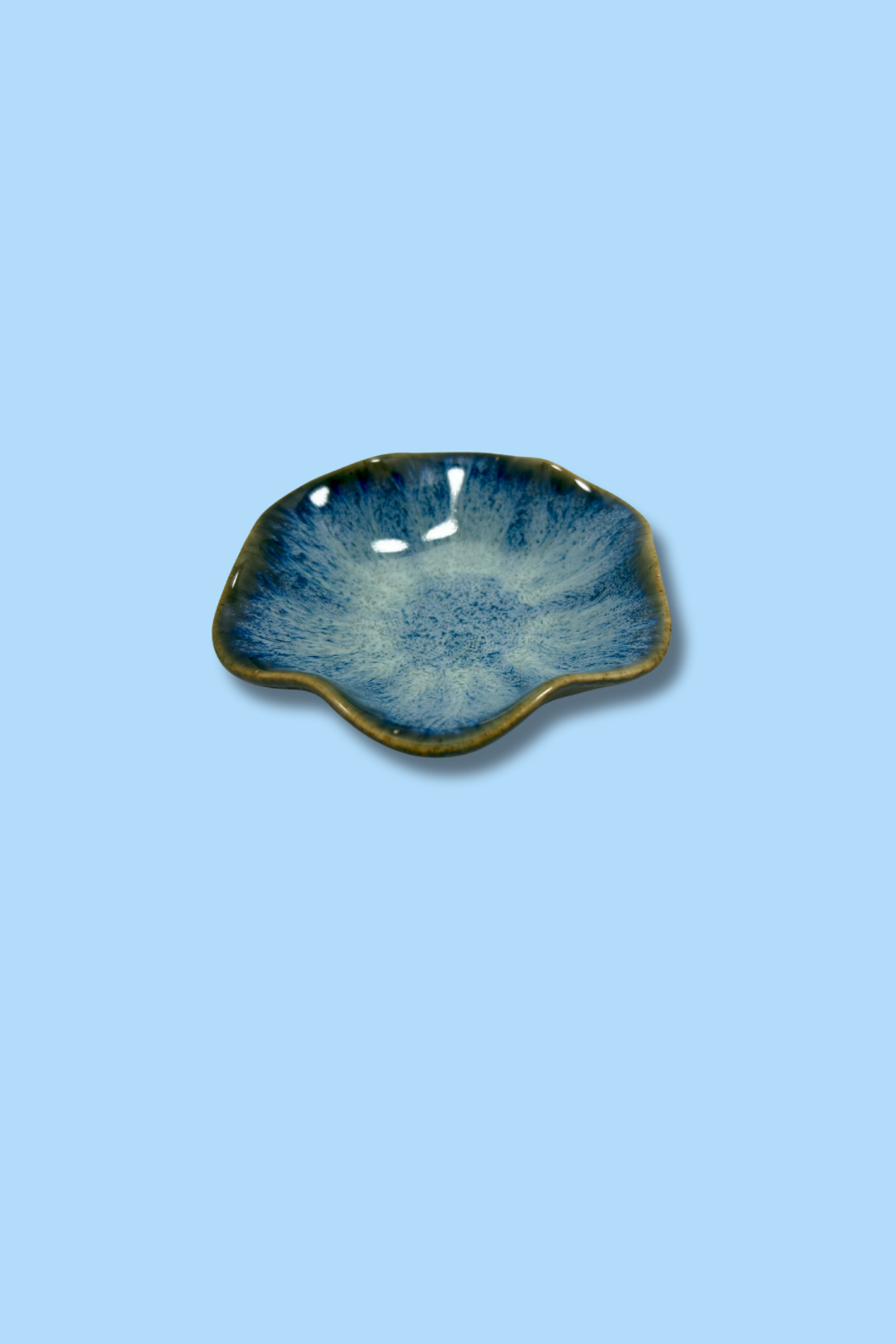 Ceramic dish with blue glaze on a light blue background