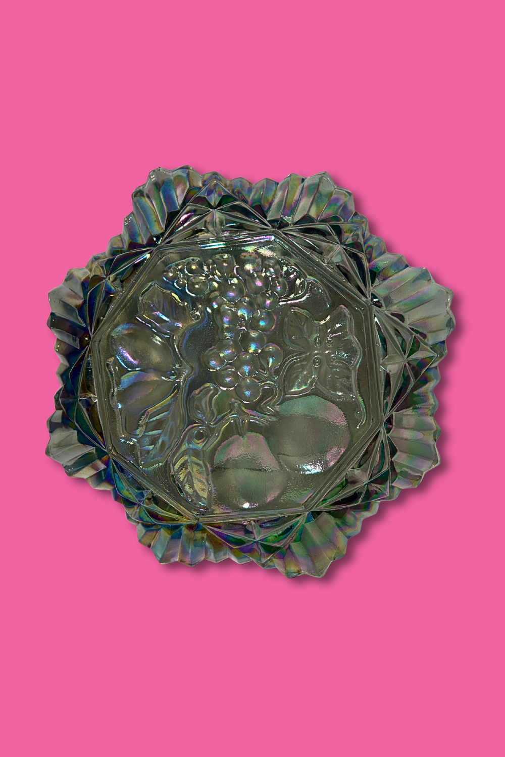 Decorative glass bowl with floral design on a pink background