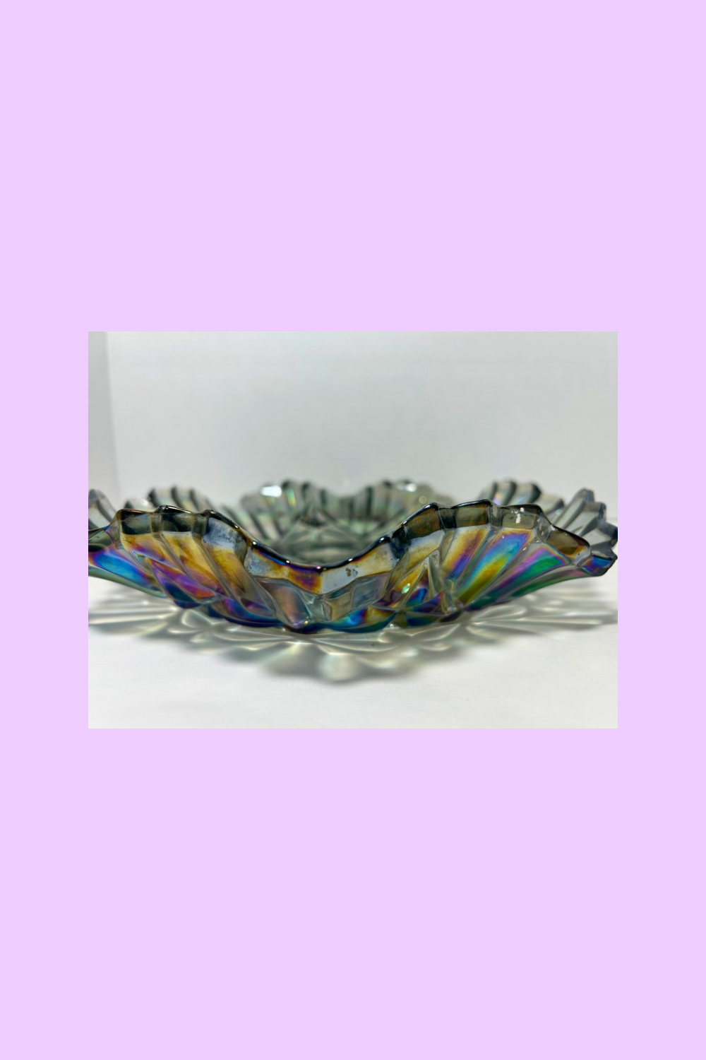 Decorative glass bowl with colorful stripes on a light purple background