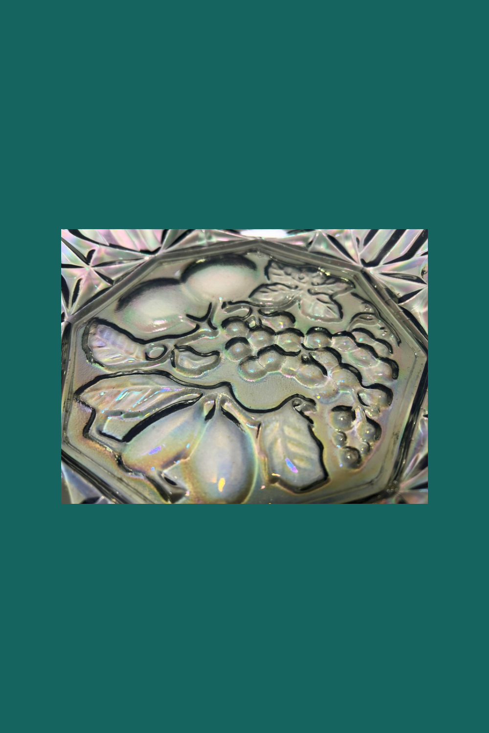 Decorative stone with floral and fruit design on a green background