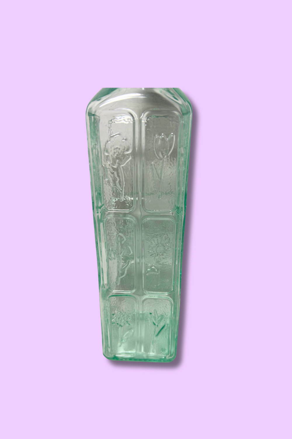 Decorative glass item with engraved design on a purple background