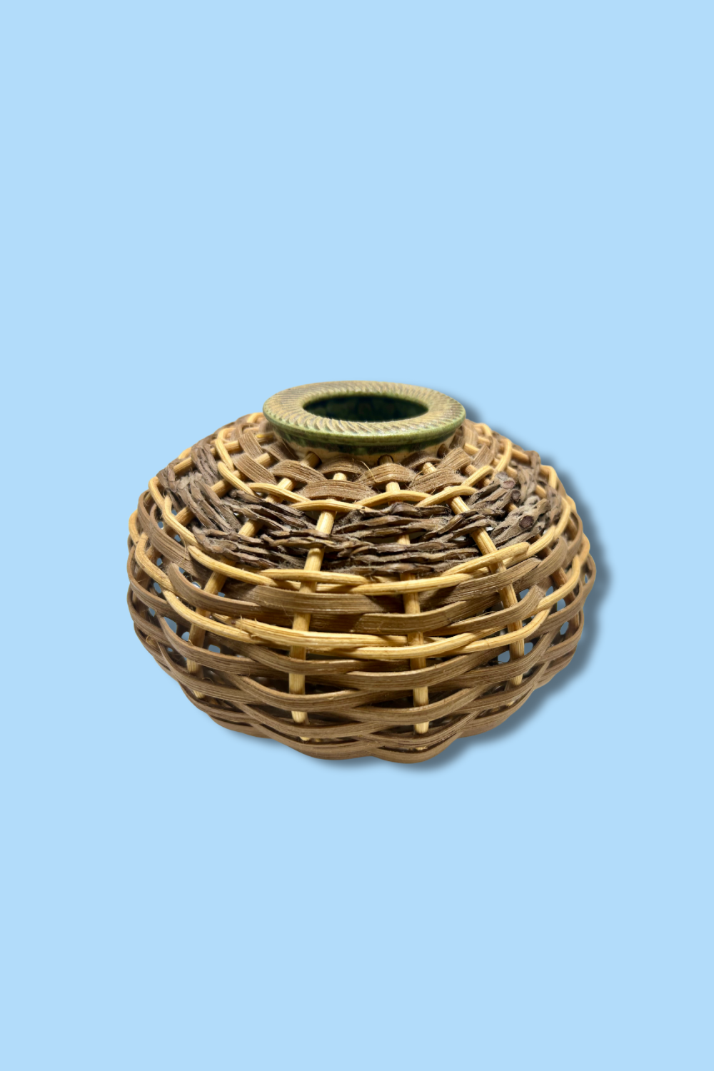Woven rattan candle holder on a light blue background