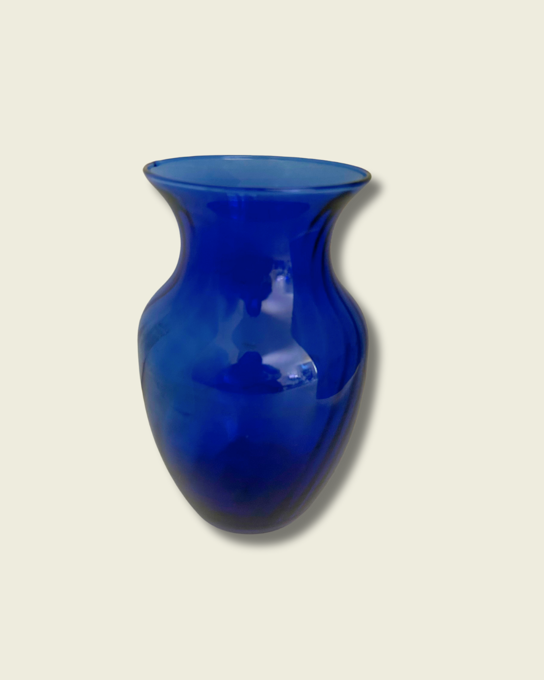 Blue glass vase on a beige background