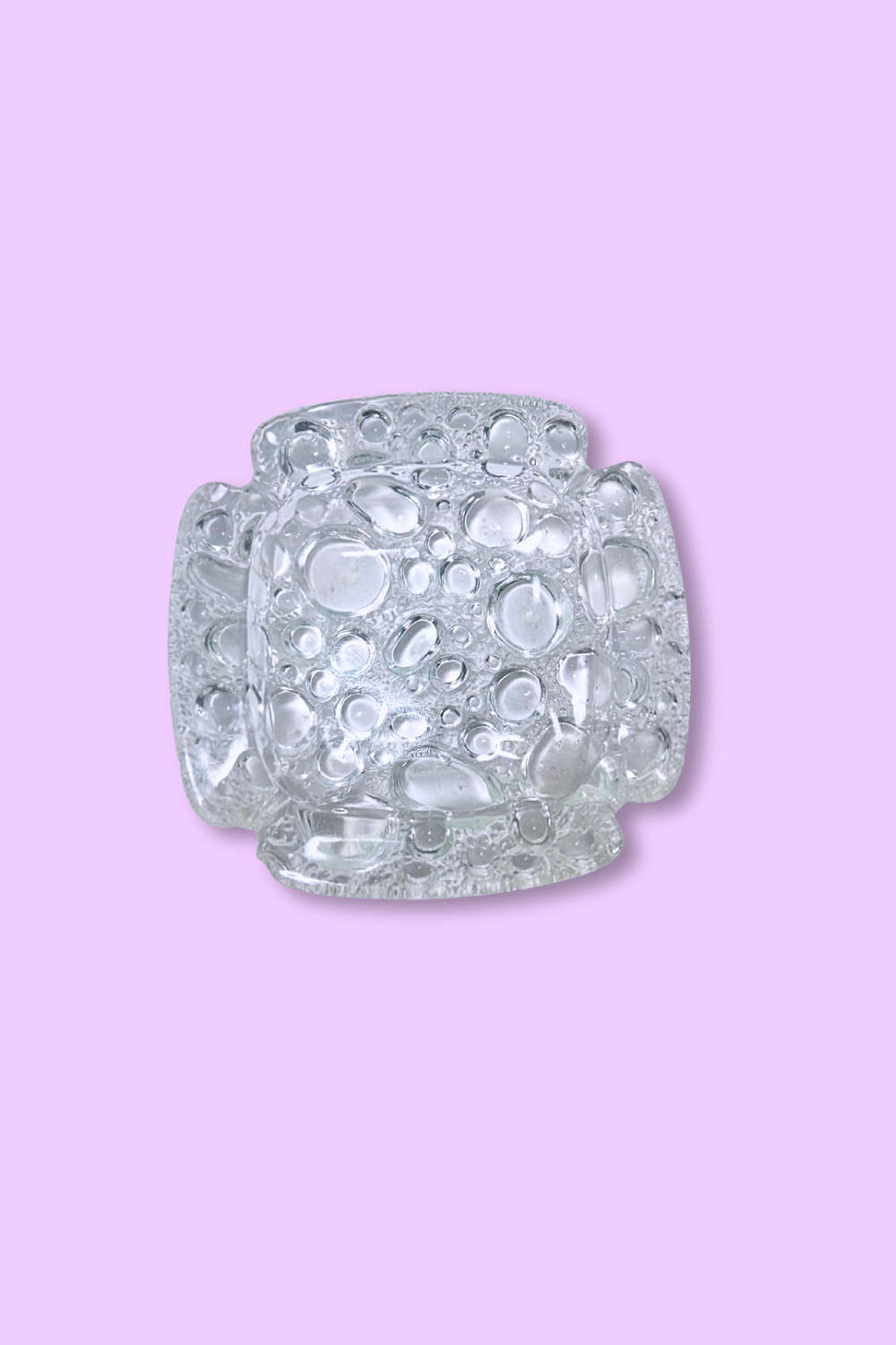 Decorative candle holder with textured surface on a pink background