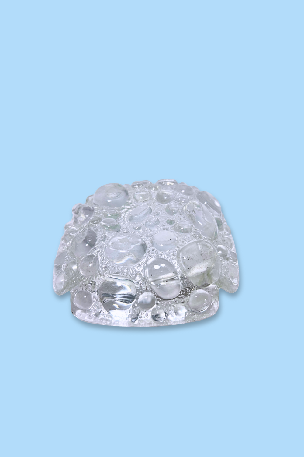 Clear ashtray on a light blue background