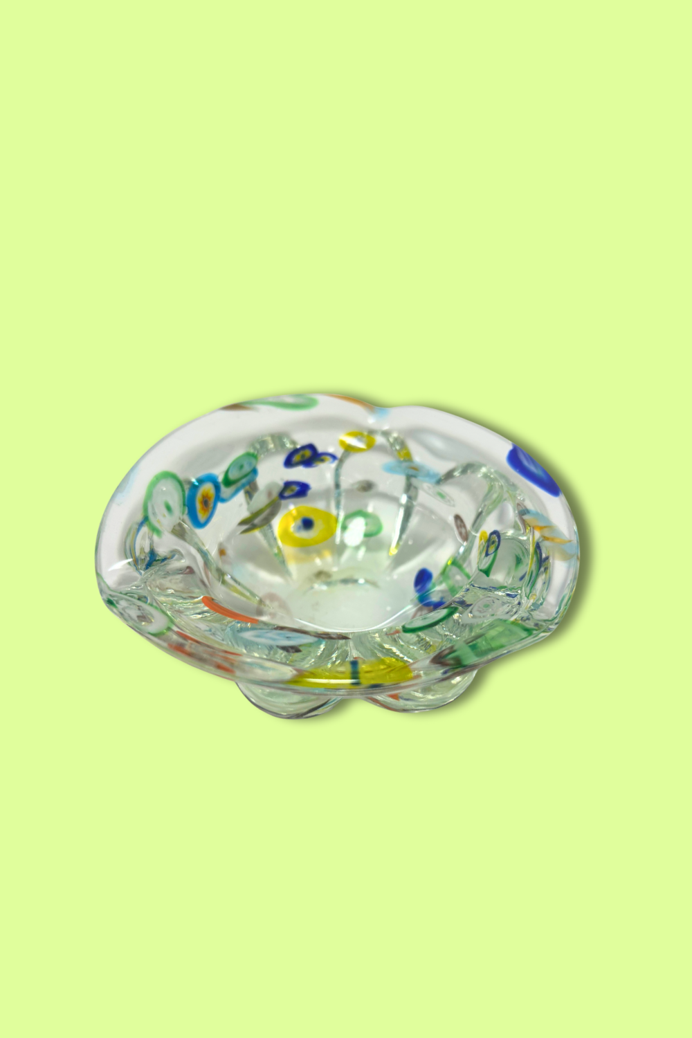 Decorative glass bowl with floral designs on a light green background