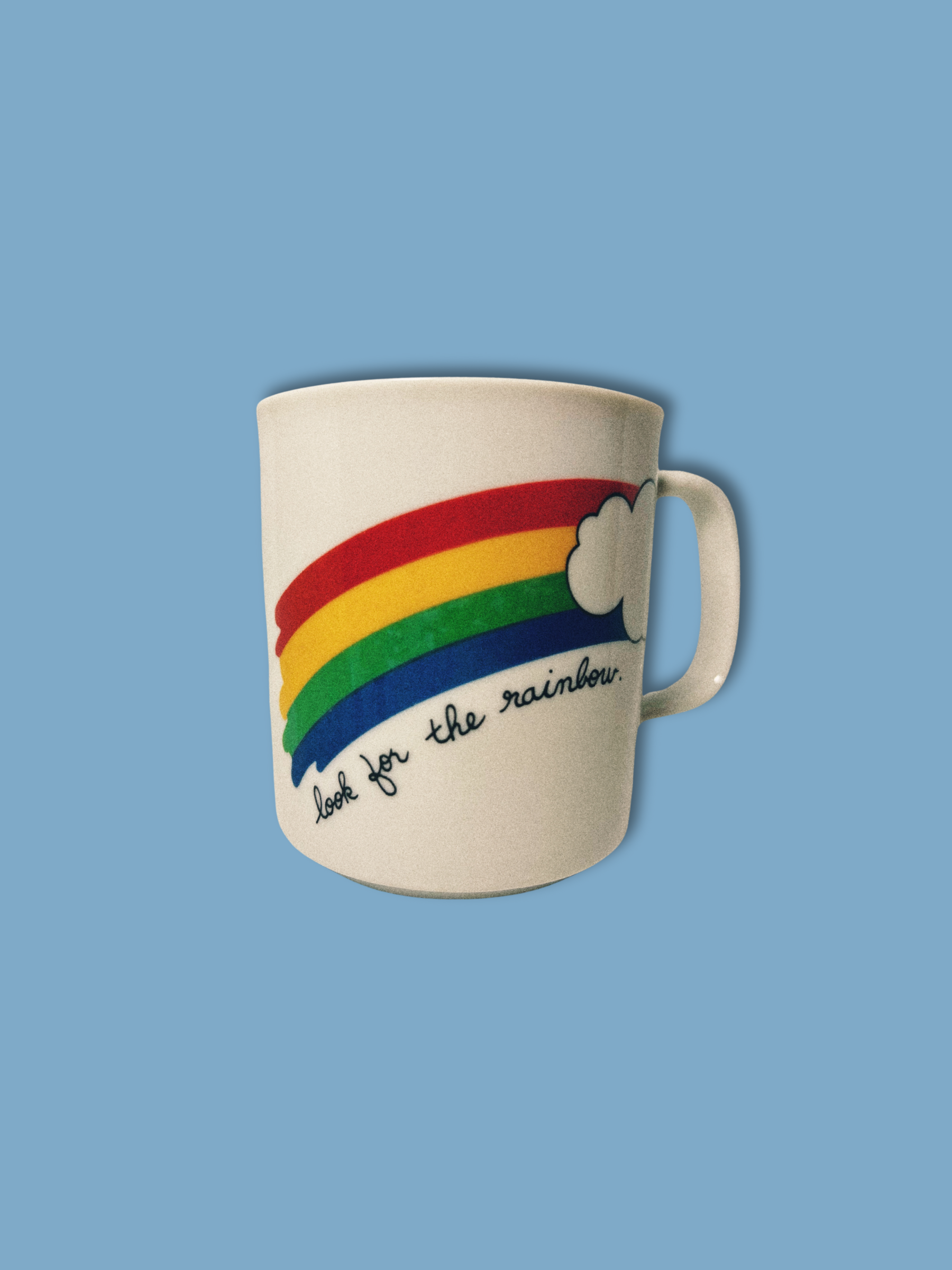 White ceramic mug with rainbow and positive quote.