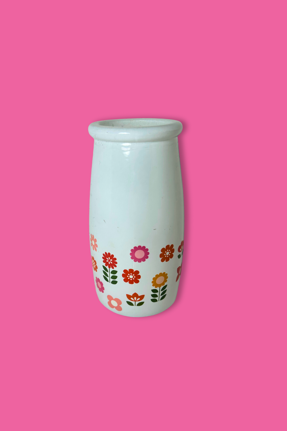 White vase with floral patterns on a pink background