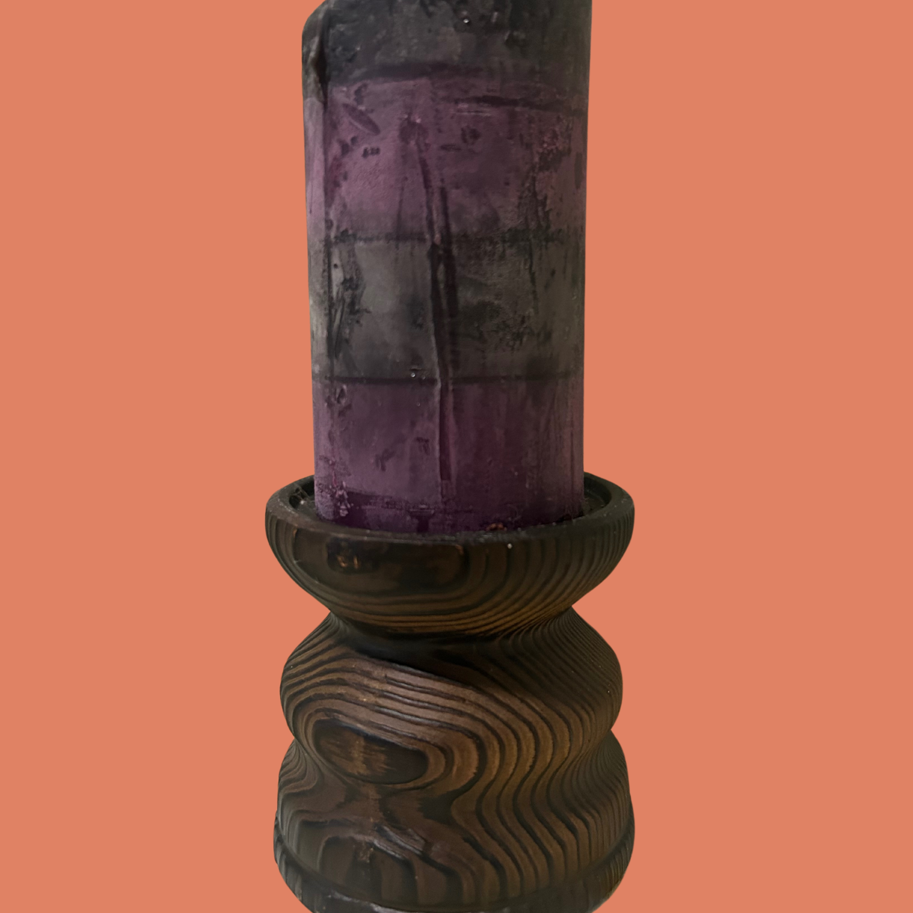 A brown Japanese clay wooden candle riser with a cylindrical shape, displayed against an orange background.