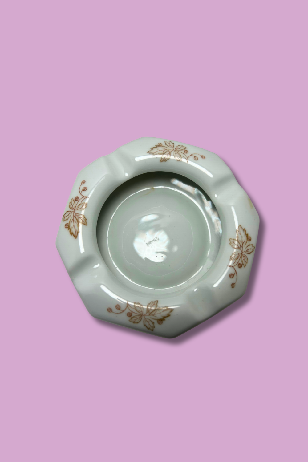Decorative ceramic ashtray with floral patterns on a pink background