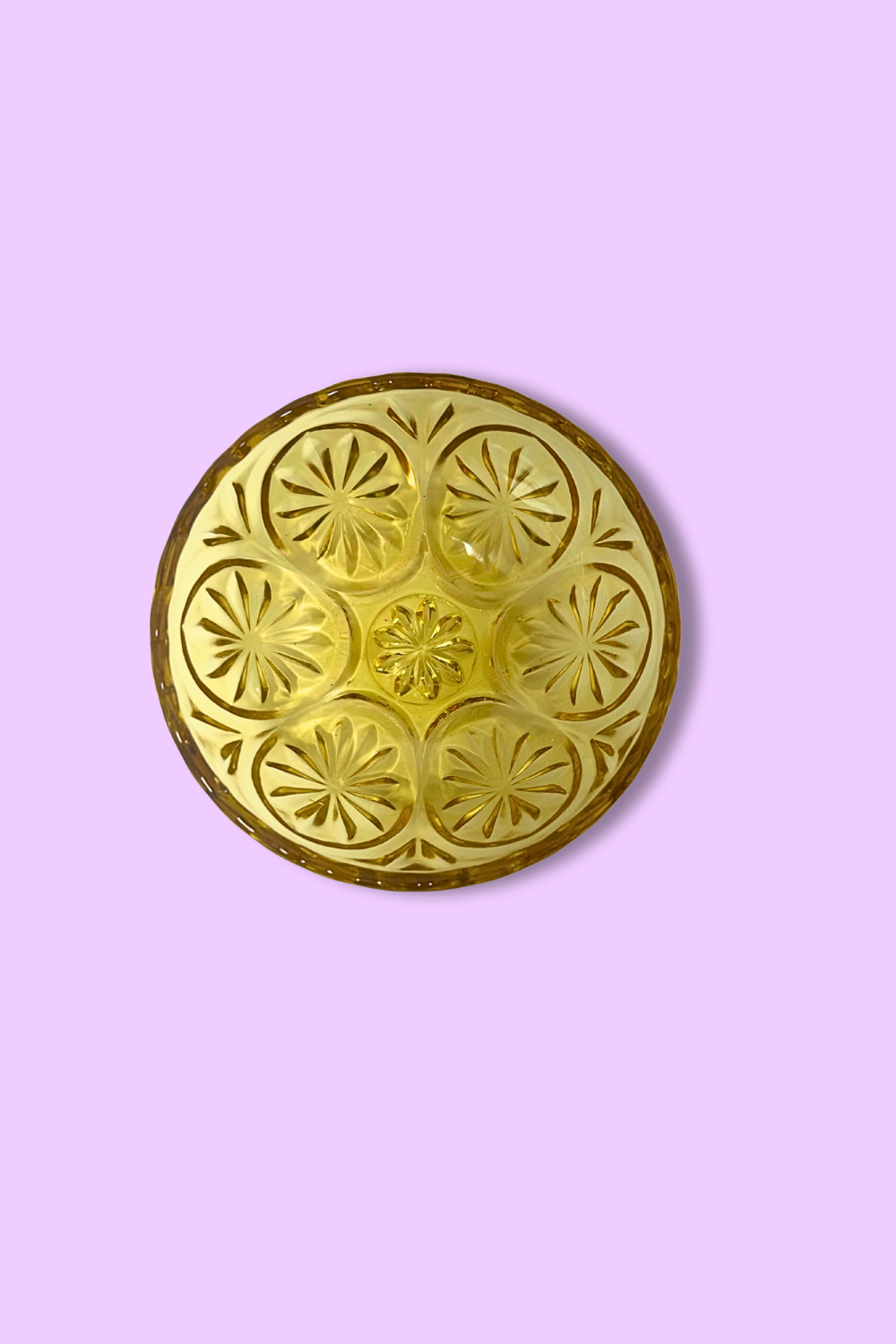 Decorative gold circular object on a pink background