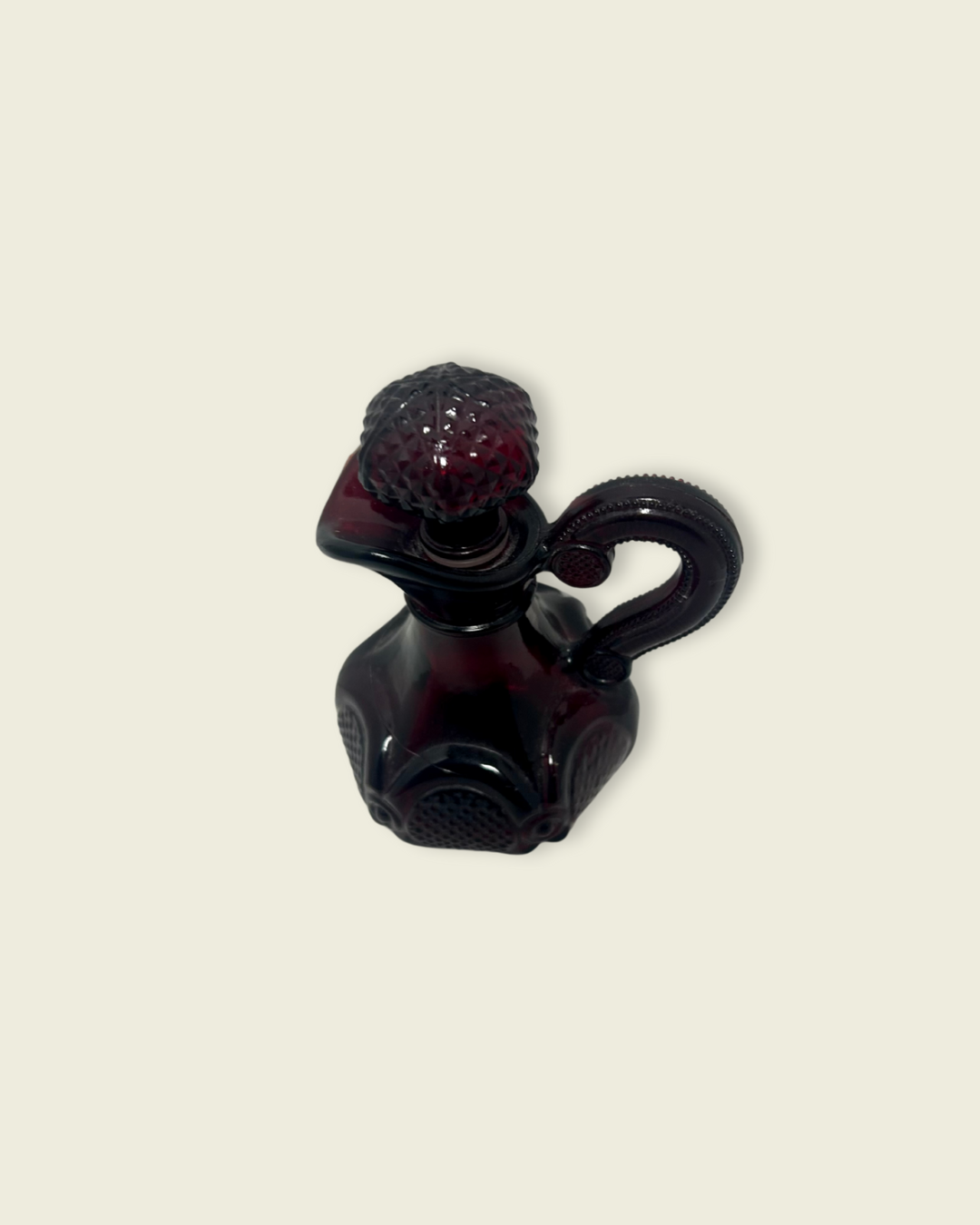 Black and red glass bottle on a beige background