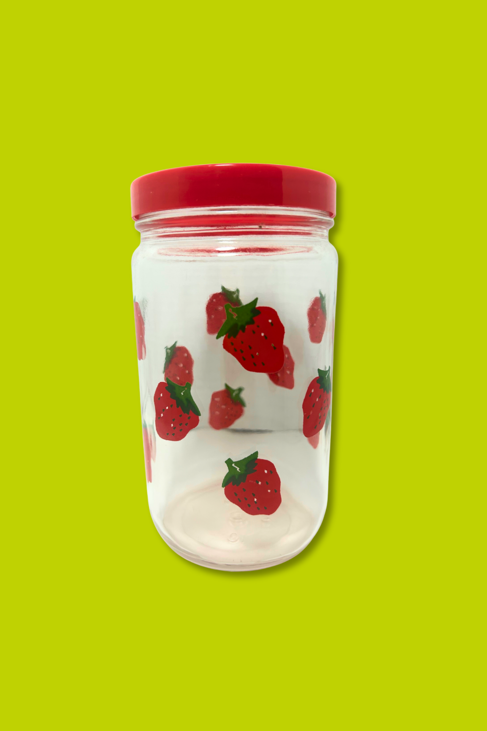 Clear container with red lid and strawberry pattern on a green background