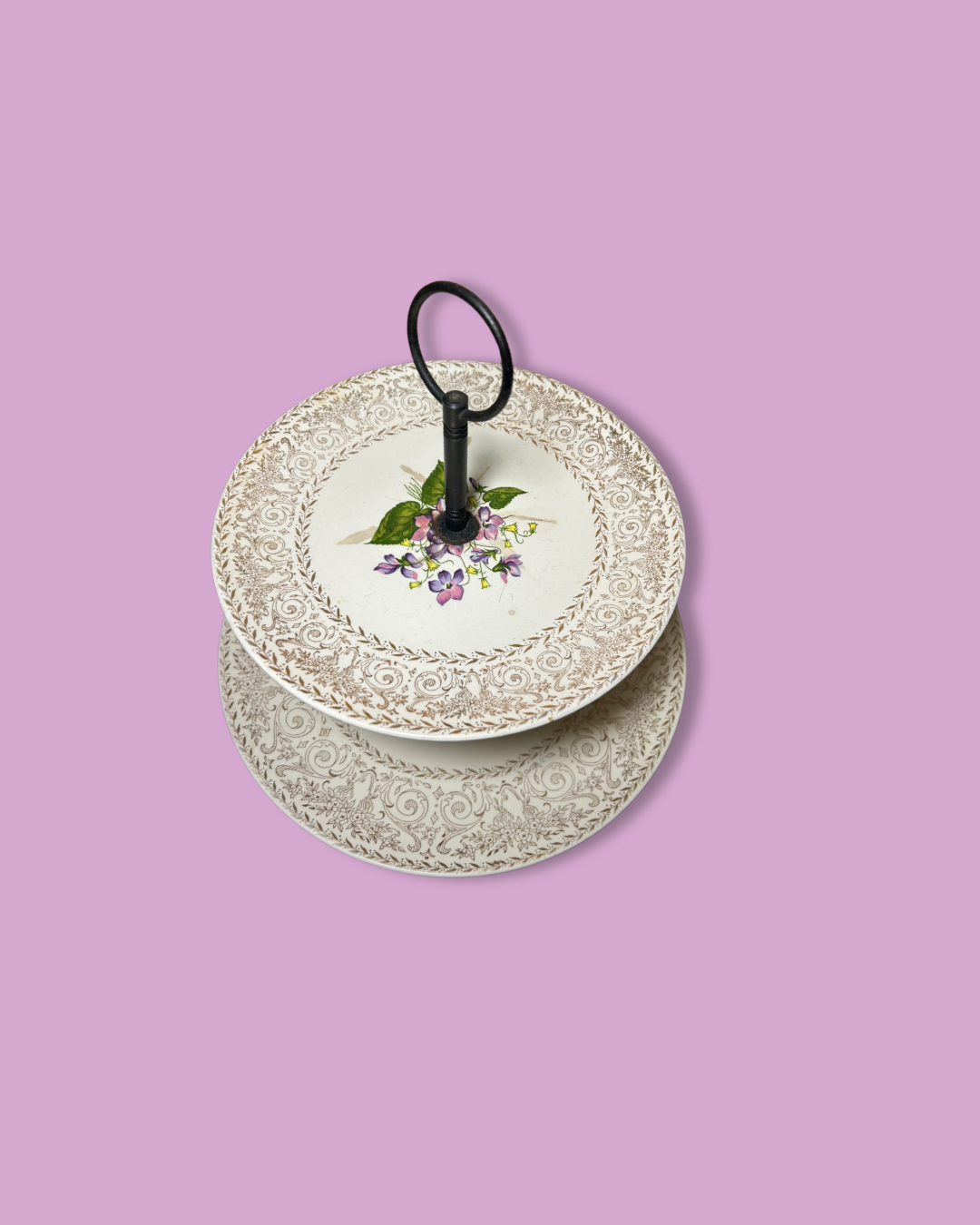 Stack of decorative plates with floral design on a pink background