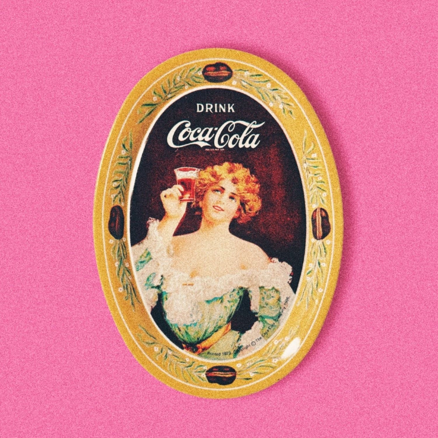 A vintage 1970s oval-shaped Coca Cola collectible plate featuring a 1917 Gibson Style Art design with a woman holding a Coca Cola glass.