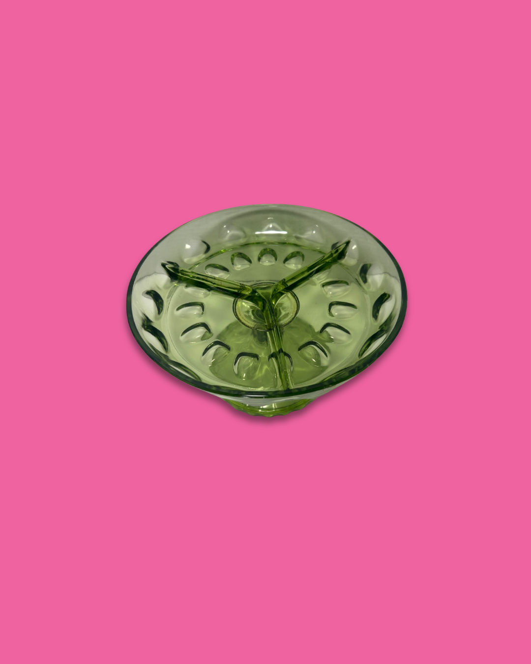 Green glass bowl on a pink background