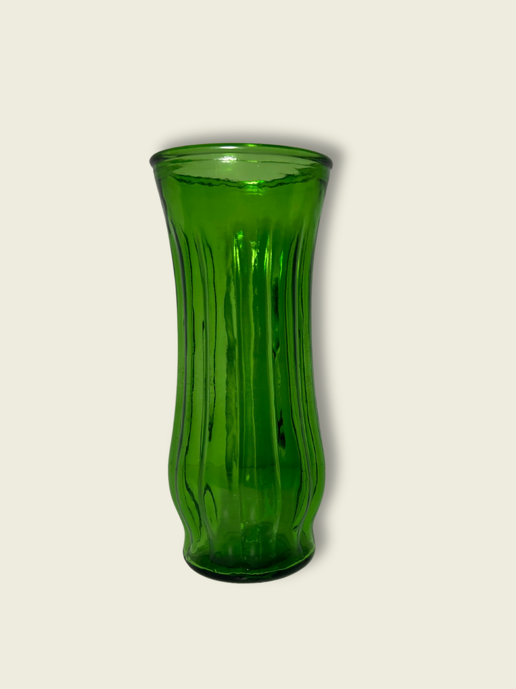 A green glass vase with a ribbed design, displayed against a white background.