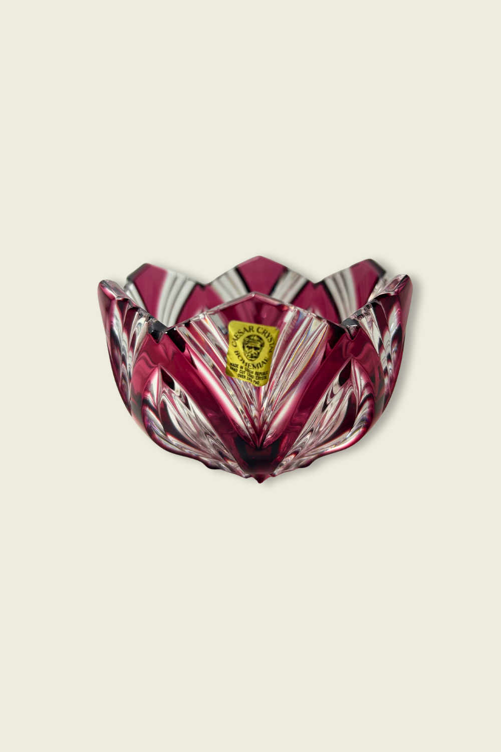 Decorative glass bowl with a red and clear pattern on a beige background