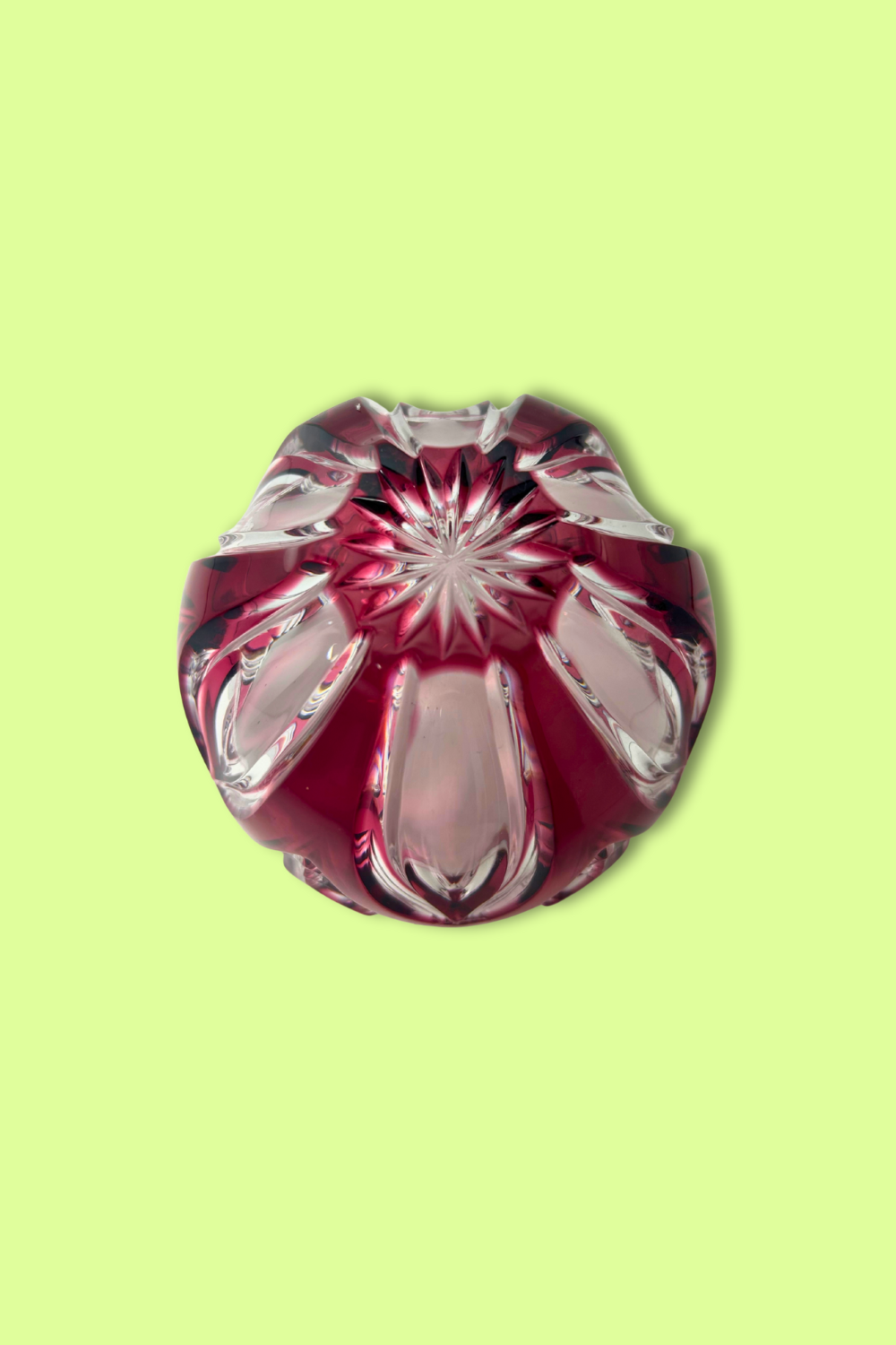 Decorative glass item with red and clear design on a light green background