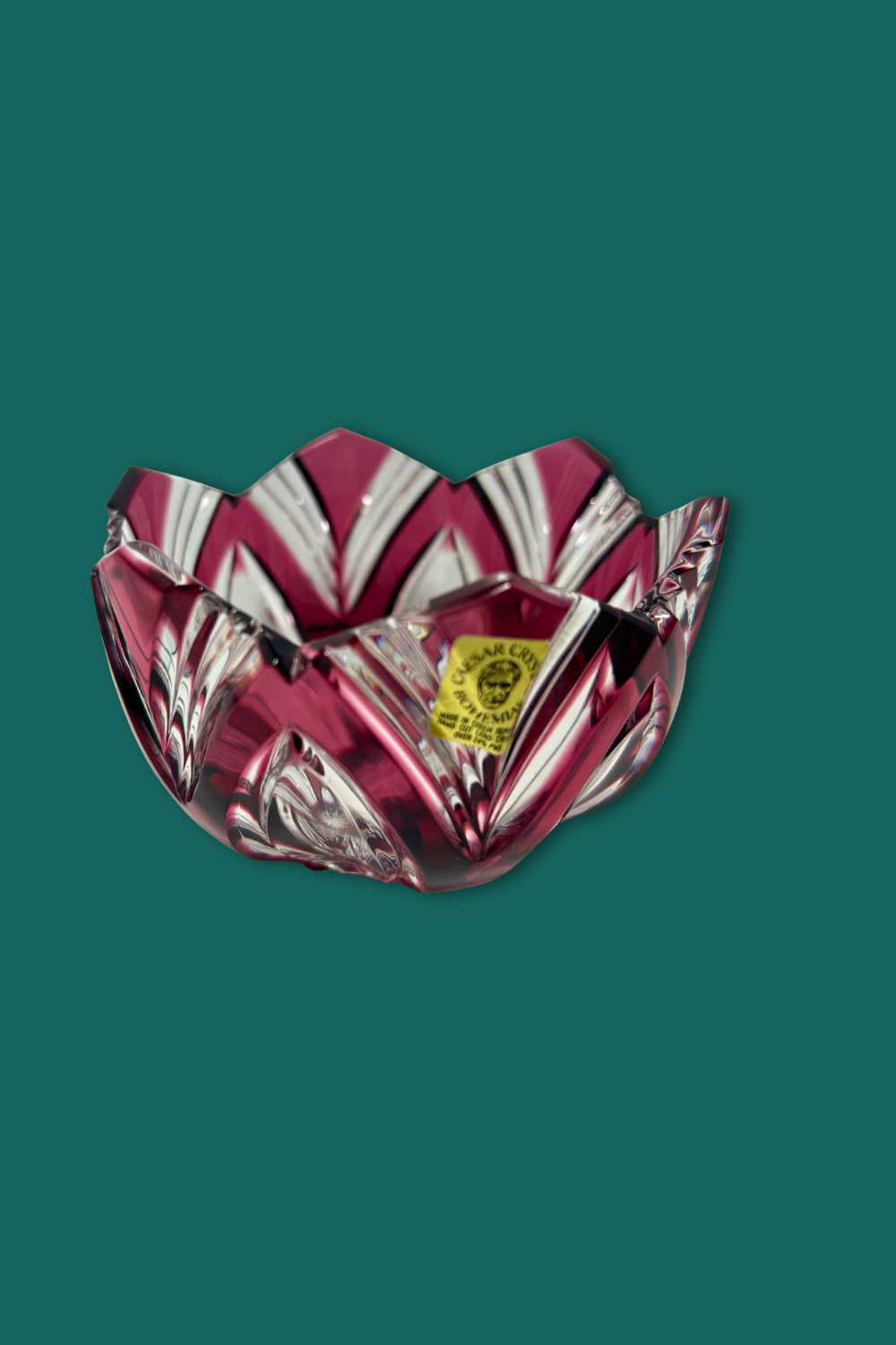 Decorative glass bowl with a red and clear pattern on a green background