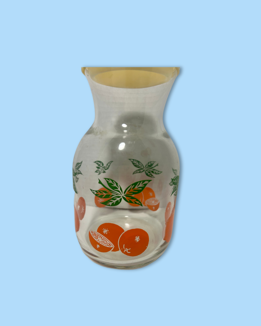 Glass vase with fruit design on a light blue background