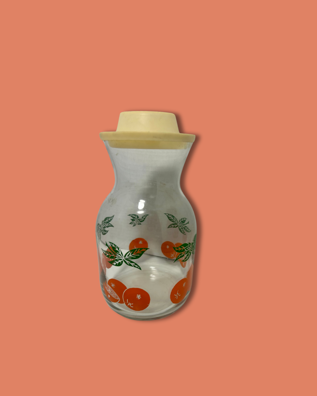 Glass bottle with wooden cap on a peach background