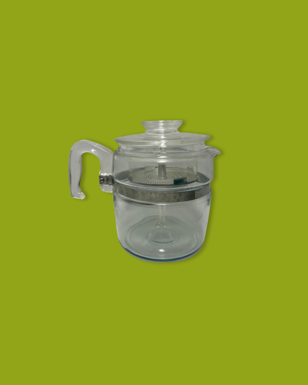 Clear glass teapot with a silver lid on a green background