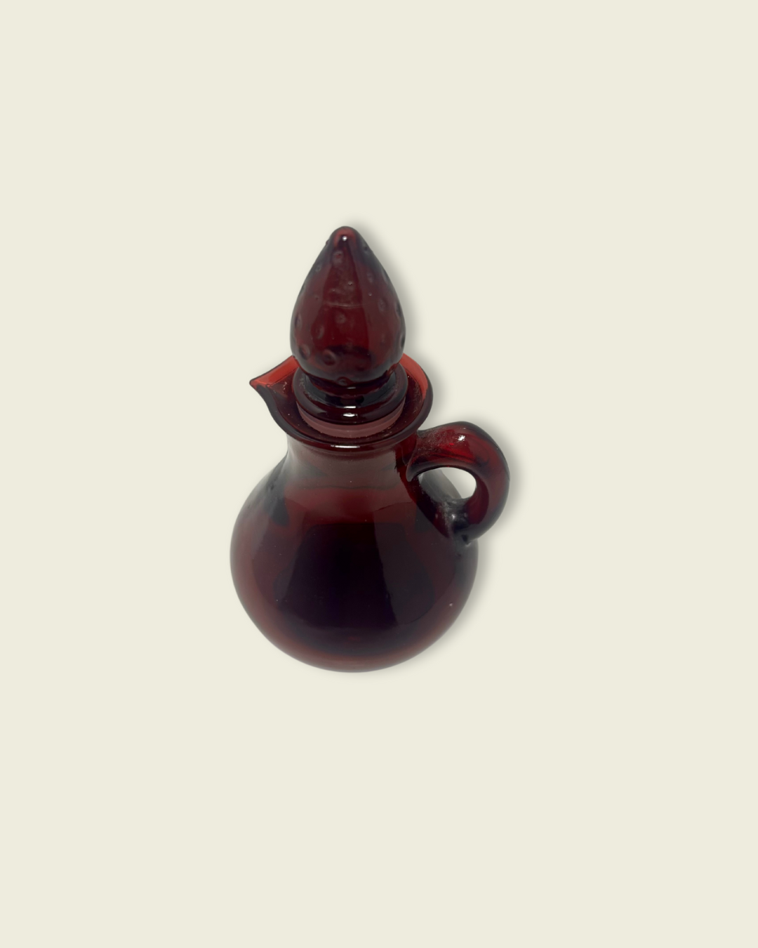 Red glass cruet on a beige background
