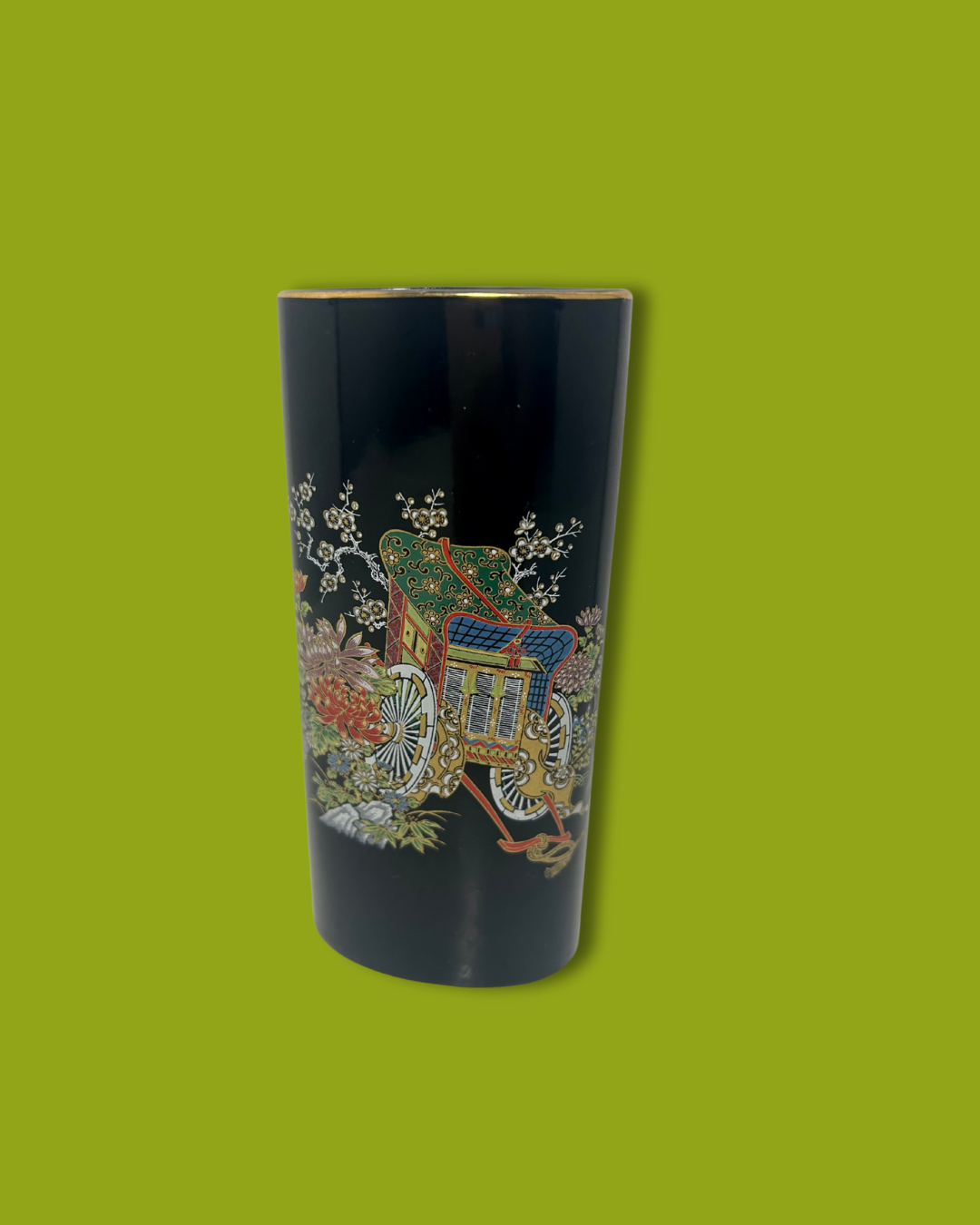 Decorative black vase with colorful design on a green background