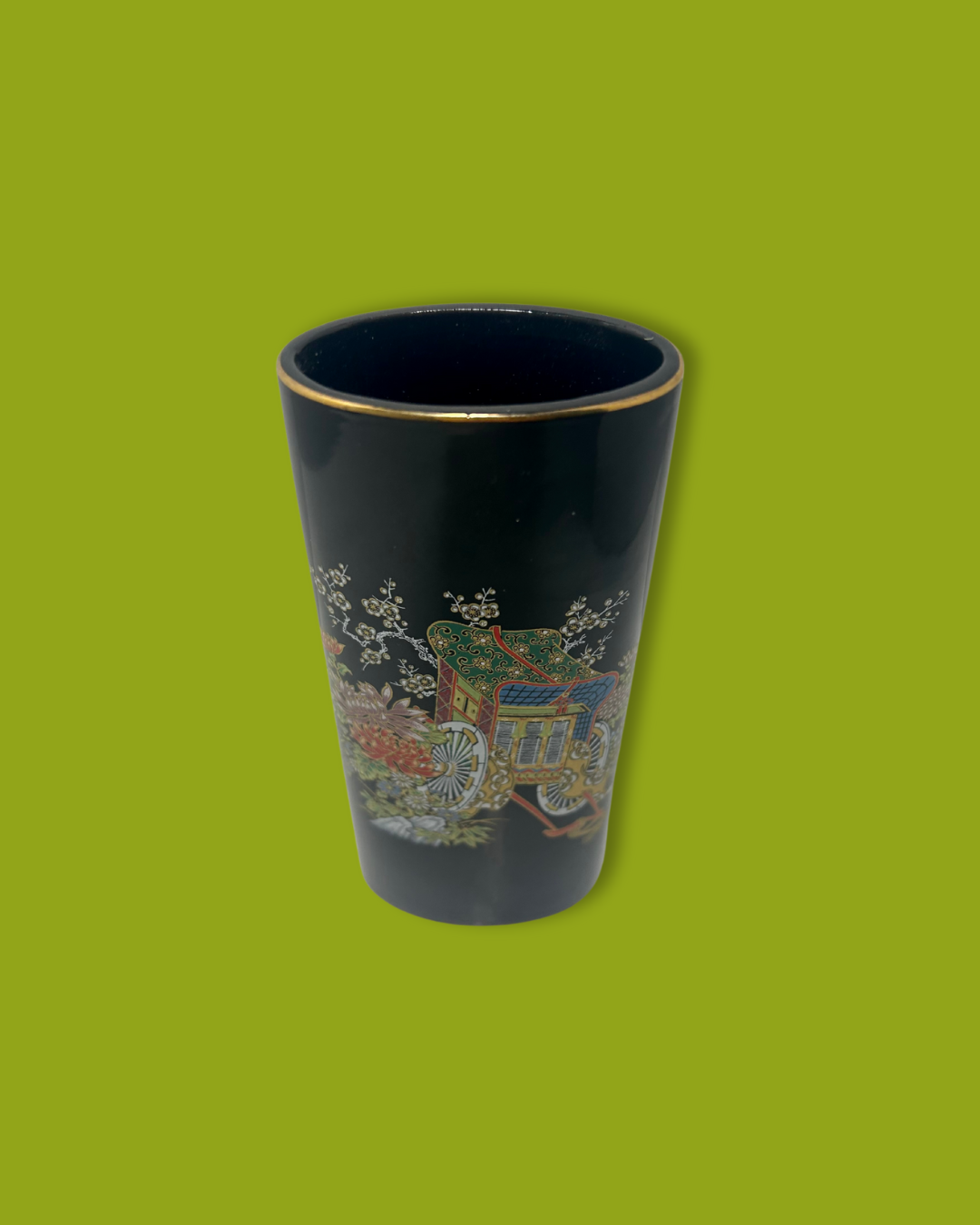 Black cup with colorful floral design on a green background