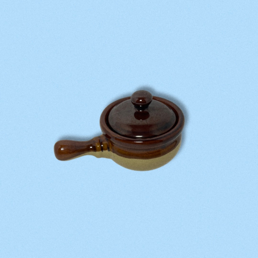 A brown and beige vintage stoneware French onion soup bowl with a lid and handle.