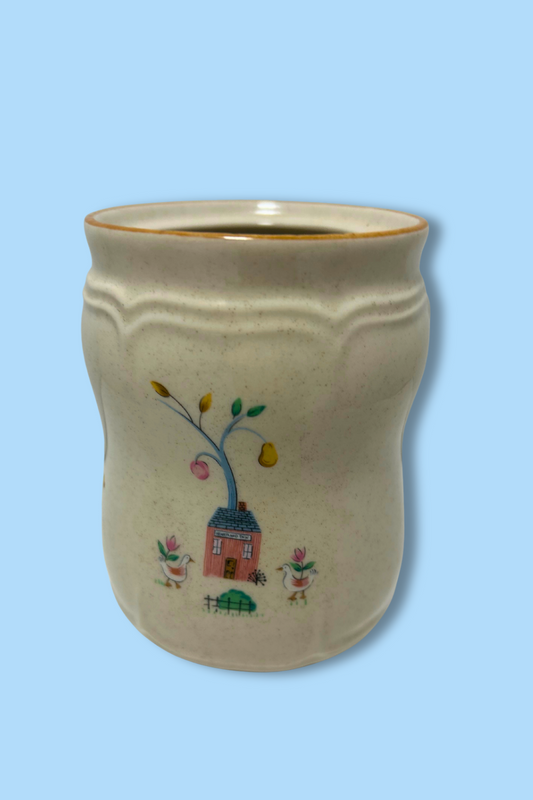 Ceramic mug with decorative geese and house design on a light blue background