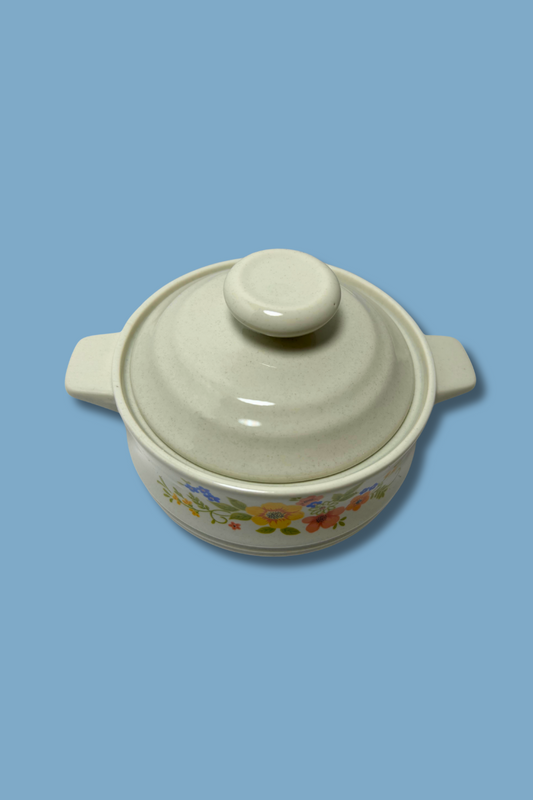 Ceramic casserole dish with floral patterns on a blue background