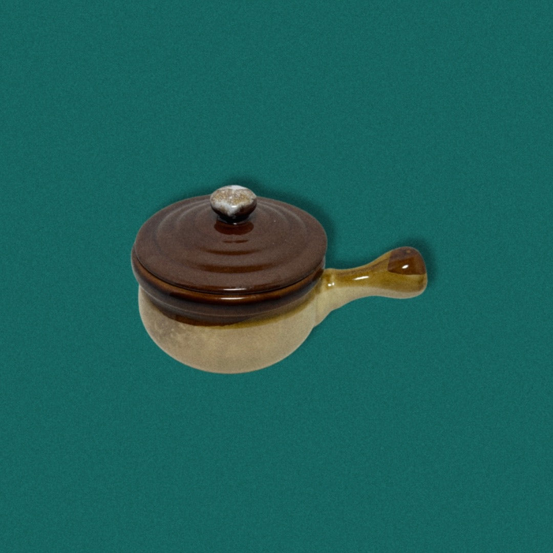 Photo of vintage soup crock on teal background