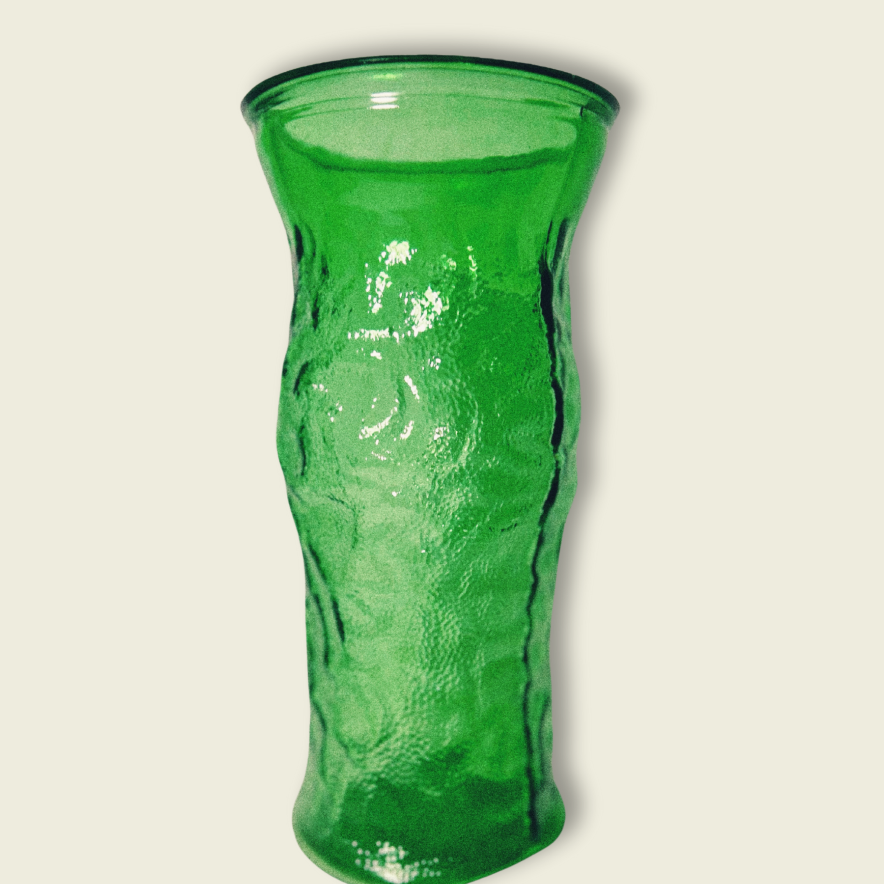 A vintage emerald green glass vase with a textured surface, featuring a classic hoosier design.
