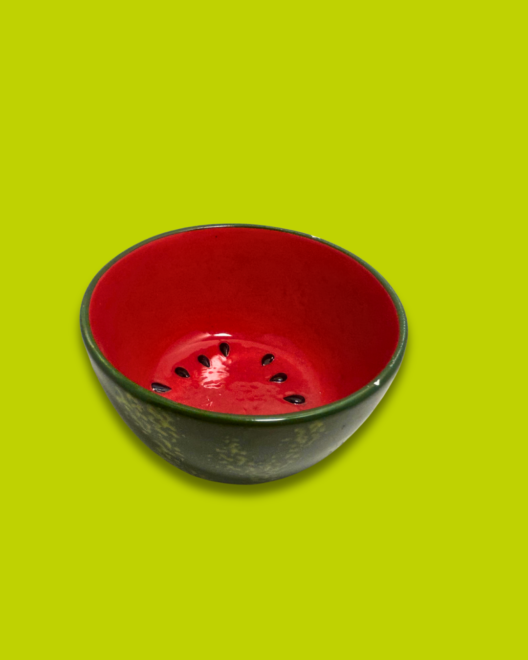 Red ceramic bowl with black speckles on a green background