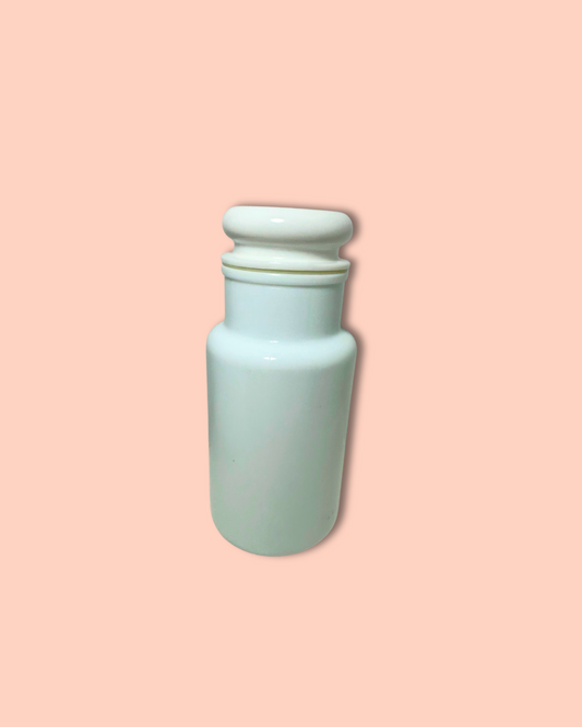 Light blue ceramic jar with a white lid on a pink background