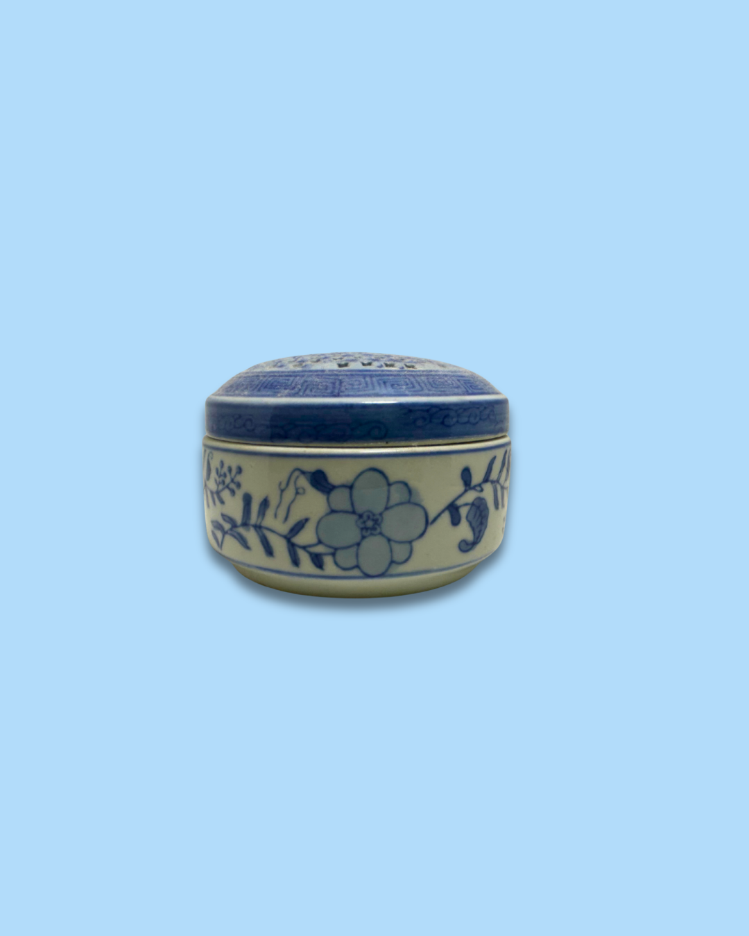 Ceramic jar with floral design on a light blue background