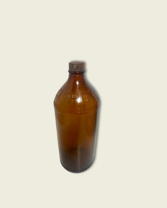 Brown glass bottle with a label on a beige background