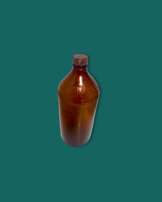 Brown bottle with cap on a green background