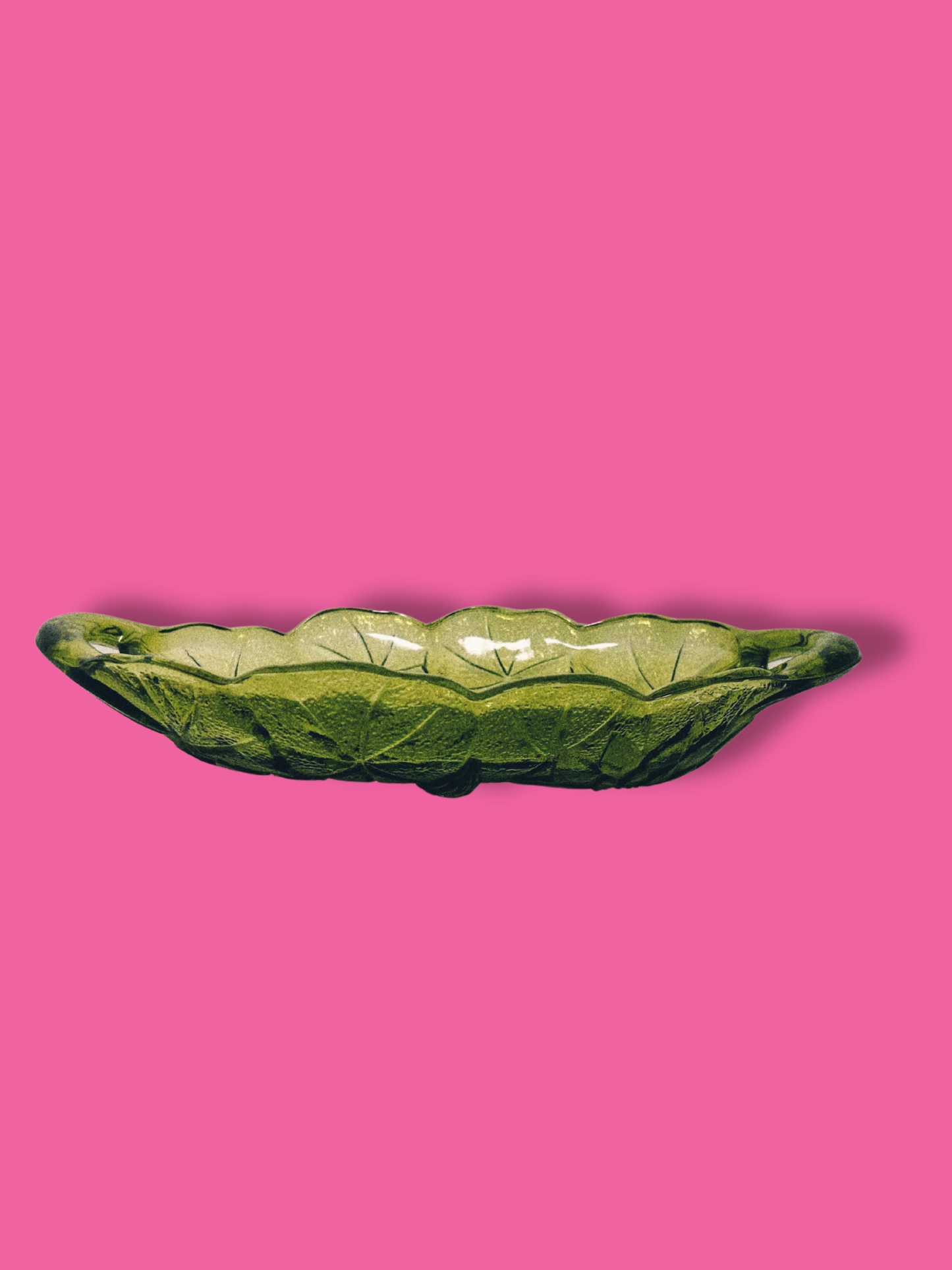 Avocado green glass candy dish with a sunflower pattern on a pink background.