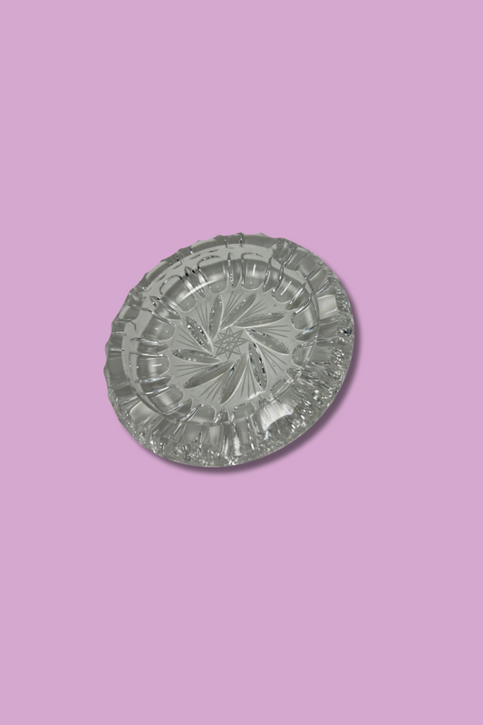 Clear crystal ashtray with Hob Star and pinwheel pattern on a lavender background