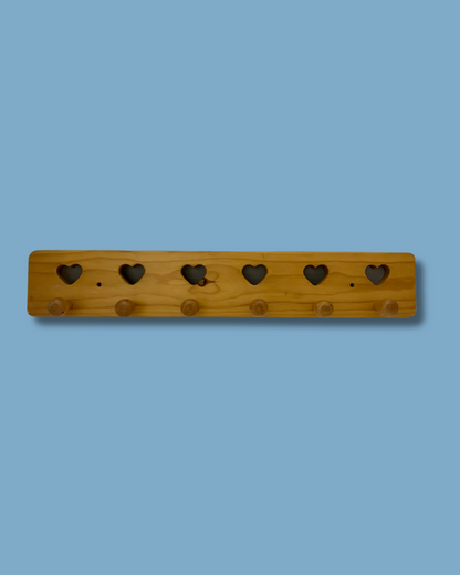 Wooden pegboard with heart-shaped holes on a blue background