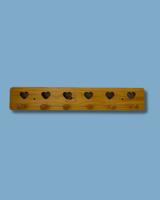 Wooden pegboard with heart-shaped holes on a blue background