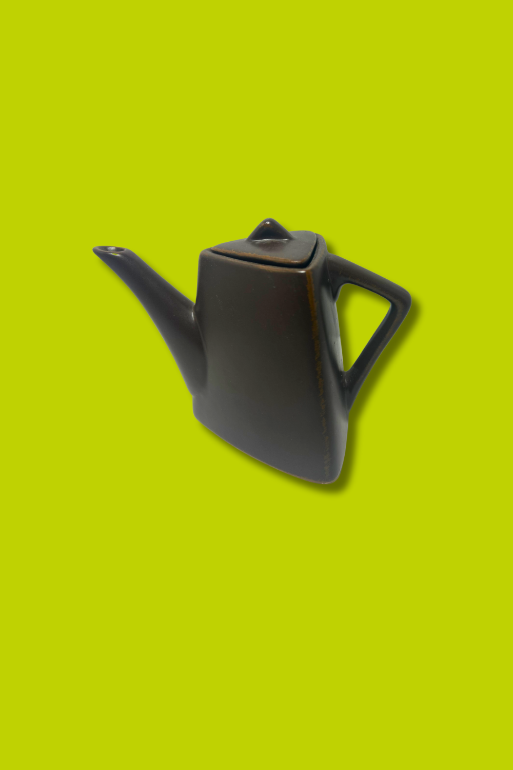 Black teapot on a green background