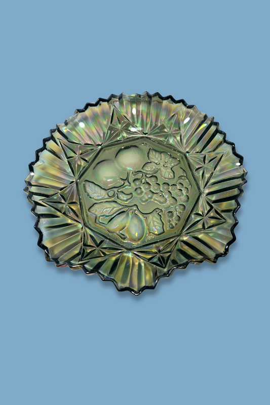 Decorative vintage glass plate with fruit design on a blue background