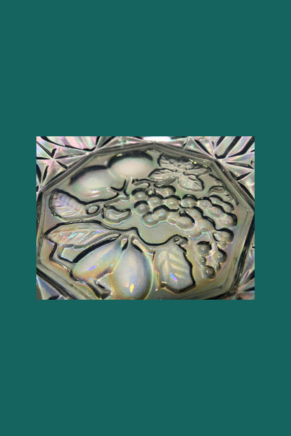 Decorative stone with floral and fruit design on a green background