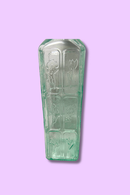Decorative glass item with engraved design on a purple background