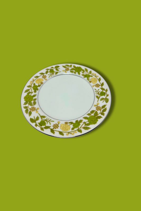 Decorative plate with retro yellow and green floral pattern on a green background