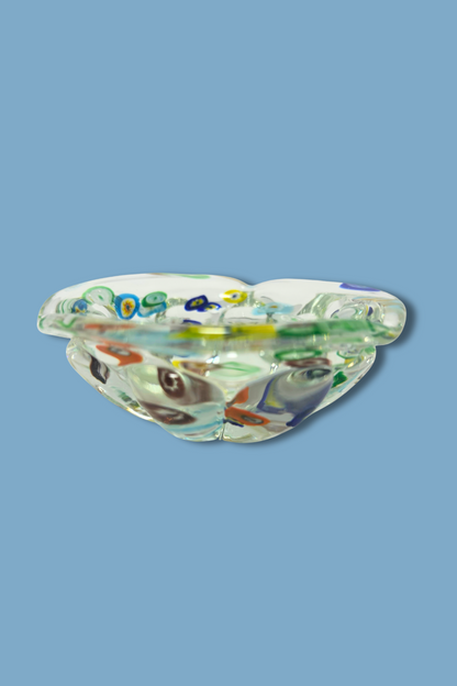 Decorative glass bowl with multicolored pattern on a blue background